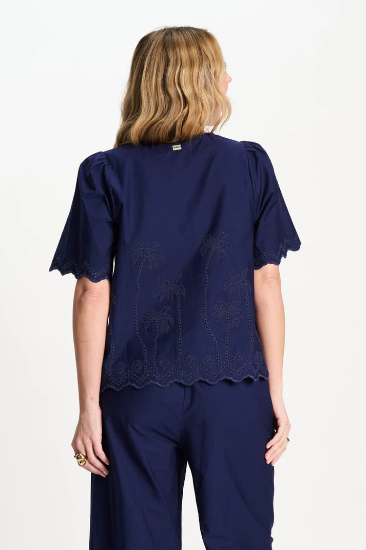 Dark blue blouse with palm tree pattern and a scalloped hem
