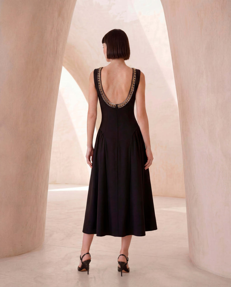 Sleeveless dress in black crêpe with chain detail.