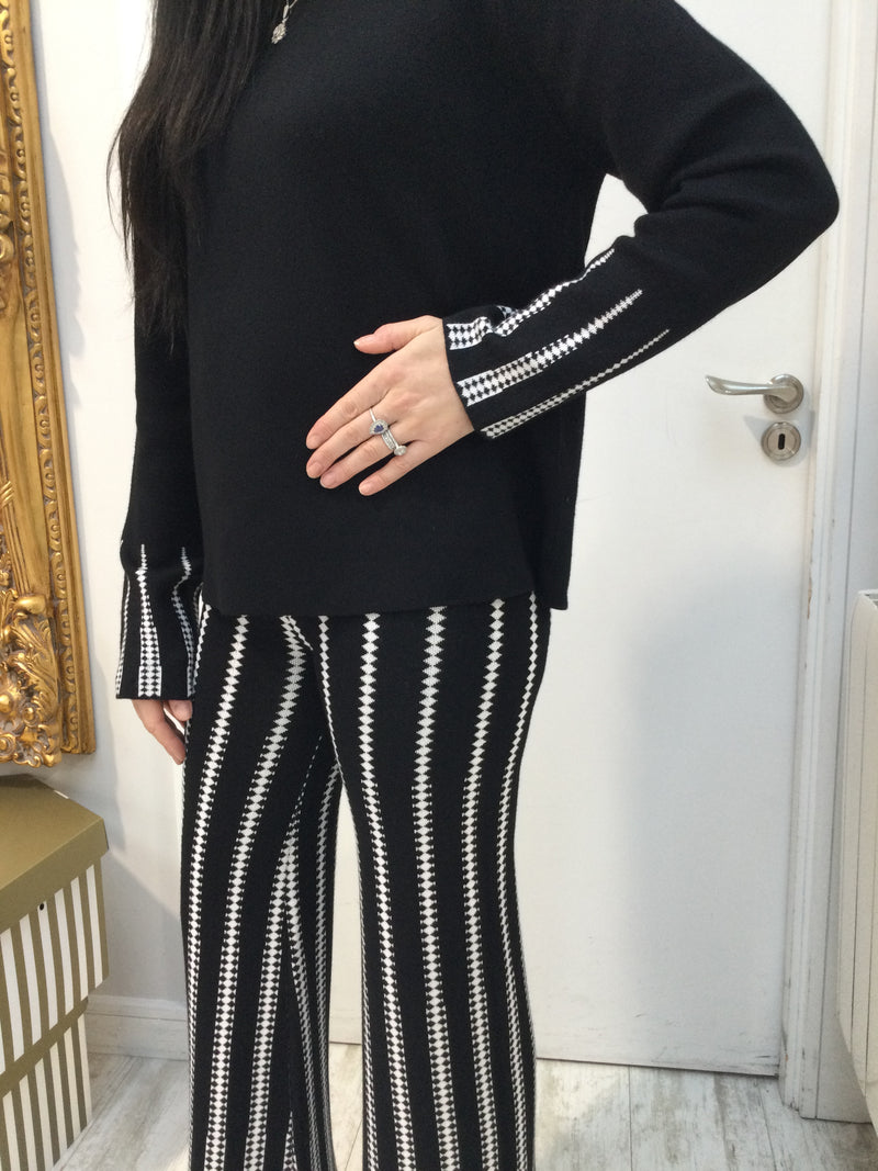 Black sweater with white pattern on cuffs