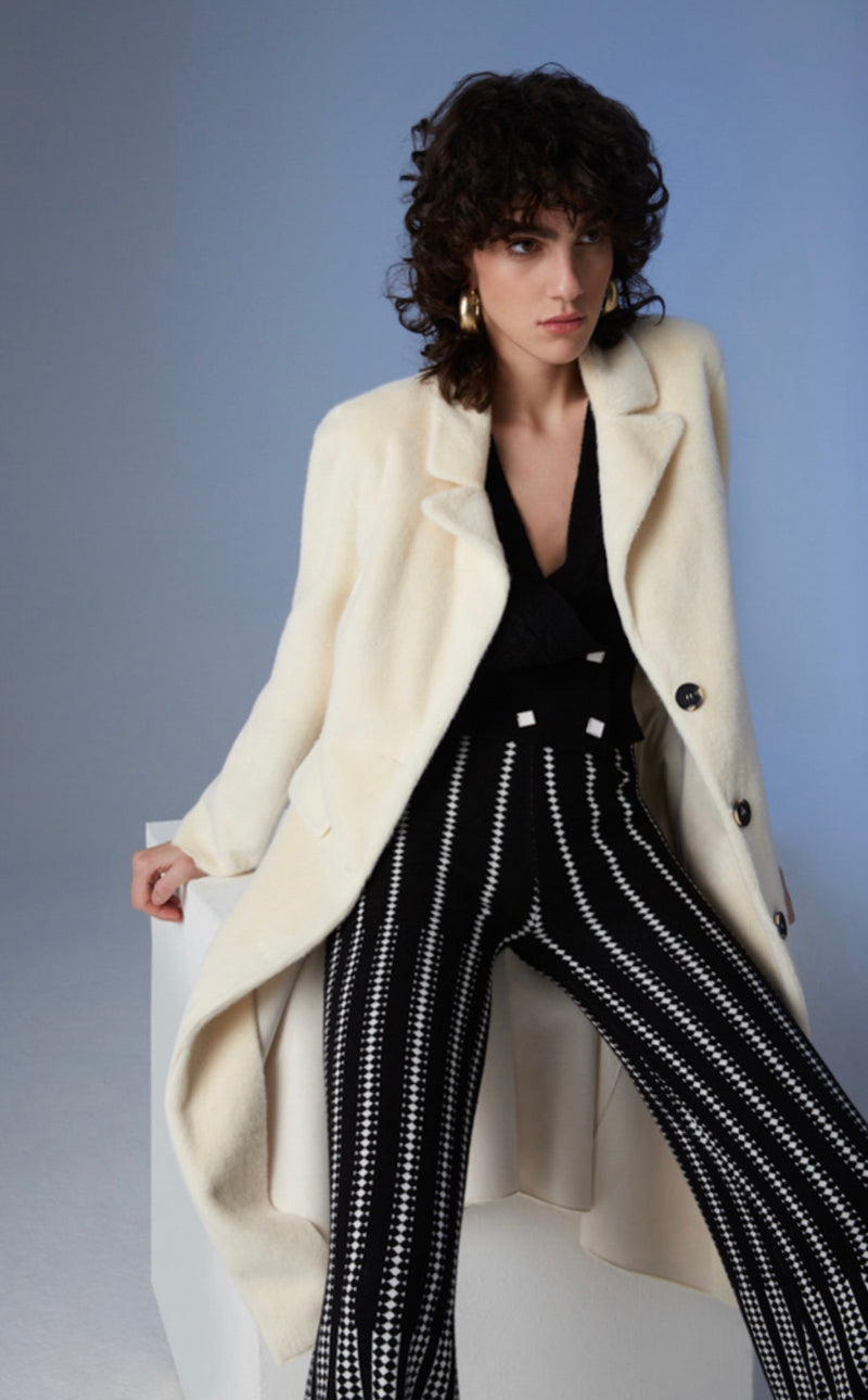 Black knitted trousers with diamond pattern in white.