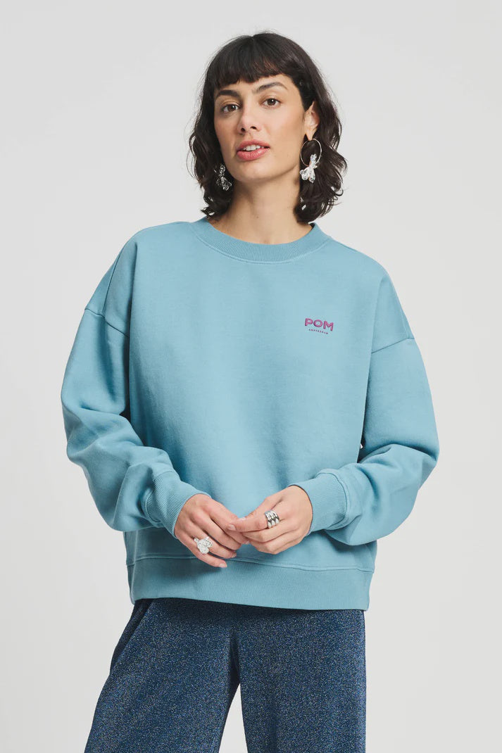 Sweatshirt in dawn blue with magenta design on back