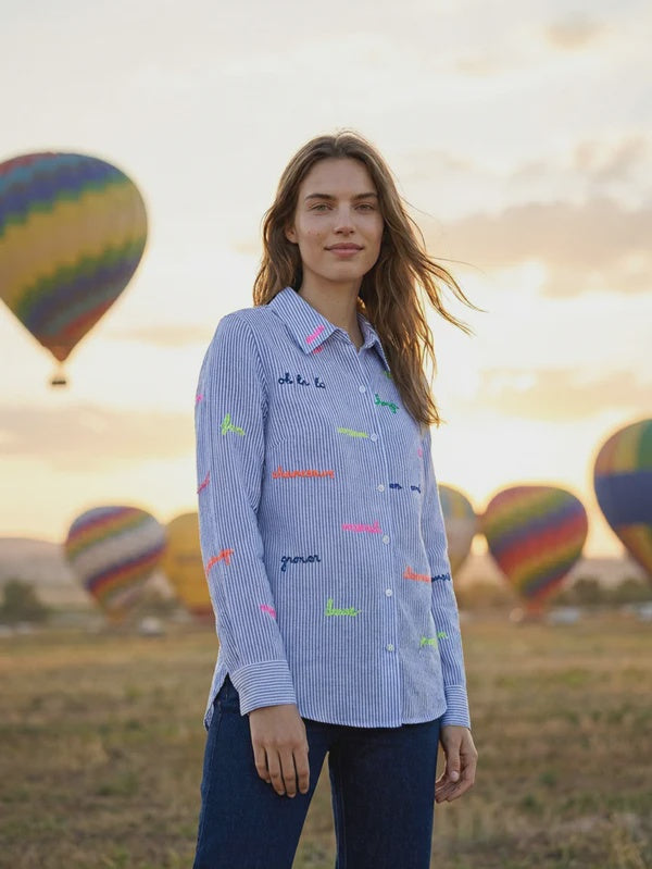 Light blue and white striped shirt with embroidered words